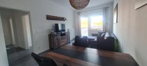 a living room with a couch and a television at Delikanto Apartments in Unterlüß