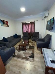 a living room with a couch and chairs and a table at Jewel Al Nasr Hotel & Apartments in Cairo