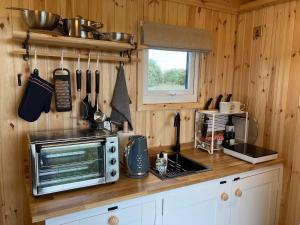 a kitchen with a counter top with a microwave at Shepherd's hut 2 at Braebost Croft in Portree