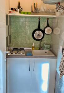 a small kitchen with a sink and a stove at Accommodates 5 people between Ibla and Ragusa in Ragusa