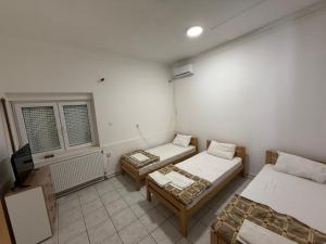 a room with two beds and a tv in it at Guest house Dunavac in Kovin