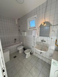 a bathroom with a toilet and a sink and a tub at Guest house Dunavac in Kovin