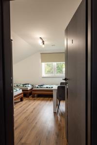 een kamer met twee bedden, een bureau en een raam bij The Country Stop Apartment in Łęki