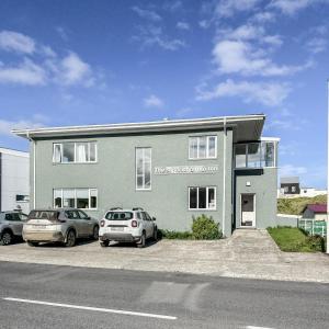 a building with two cars parked in a parking lot at The Stykkishólmur Inn by Ourhotels in Stykkishólmur