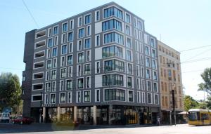 AMANO HOME Apartments في برلين: مبنى كبير على شارع المدينة مع باص