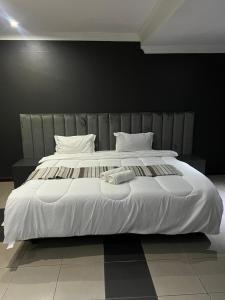 MatolaMATOLa GUEST HOME的一张白色的大床，配有白色的床单和枕头