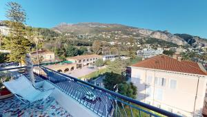 a balcony with a chair and a view of a city at Nice 2P with terrace and side sea view in Menton