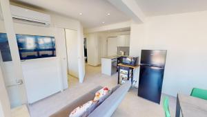 マントンにあるNice 2P with terrace and side sea viewのソファと冷蔵庫のあるリビングルーム