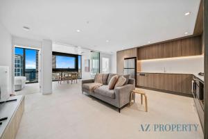 a living room with a couch and a kitchen at Brand new Luxurious 2 Bedroom Perth CBD in Perth