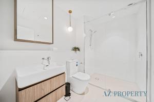 a bathroom with a toilet and a sink and a mirror at Brand new Luxurious 2 Bedroom Perth CBD in Perth