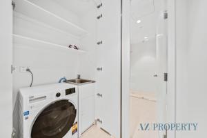 a washing machine in a bathroom with a shower at Brand new Luxurious 2 Bedroom Perth CBD in Perth