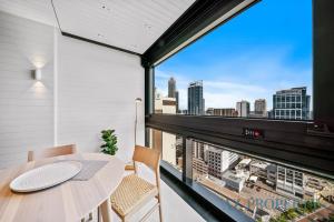a balcony with a table and chairs and a view of the city at Brand new Luxurious 2 Bedroom Perth CBD in Perth