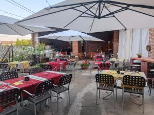 a restaurant with tables and chairs and umbrellas at B&B da Stefy in Cuccaro Monferrato