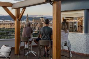 a group of people sitting on a balcony looking at the city at Hesperia Córdoba in Córdoba