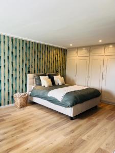 a bedroom with a large bed in a room at Chambre d'hôtes Lucia avec vue sur jardin arboré in Tournai