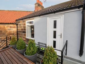 a white house with potted plants in front of it at Postmans Lodge in Middlesbrough