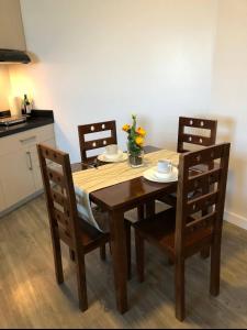 a dining room table with three chairs and a table and chairsuggest at Antara Residences - 1BR in Talisay +5 photos
