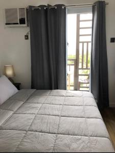 a bedroom with a bed and a window with a view at Antara Residences - 1BR in Talisay