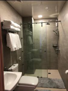 a bathroom with a shower and a toilet and a sink at Antara Residences - 1BR in Talisay