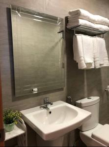 a bathroom with a sink and a toilet and a mirror at Antara Residences - 1BR in Talisay +5 photos