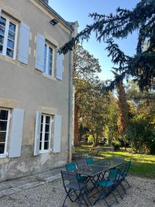 a table and chairs in front of a building at La Tour du Maine in Marmande