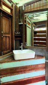 a bathroom with a white sink and a mirror at Latehouse bar อัมพวา in Ban Nong Chaeng