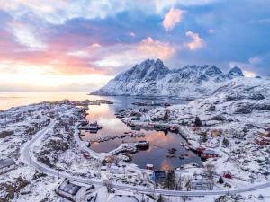 an aerial view of a town with snow covered mountains at Aurora Bay Villa Lofoten 罗弗敦极光湾海景顶层别墅 in Sund +148 photos