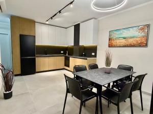 LushnjëTheGrand Stone Executive Apartment Central Lushnje的餐厅里有一张桌子和几把椅子