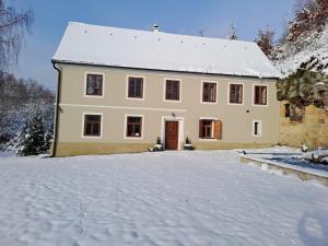 uma casa branca com neve no chão em Chalupa Zátyní - celý objekt em Dubá