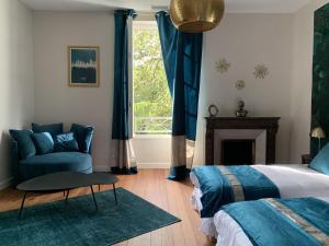 a bedroom with a bed and a chair and a window at La Tour du Maine in Marmande