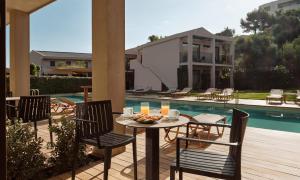 a patio with a table and chairs next to a pool at New Beach Hotel in Planos