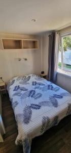 南莱潘Bungalow confortable à Nans-les-Pins de 30 m²的卧室里有一张床，床铺有蓝白相间的被子