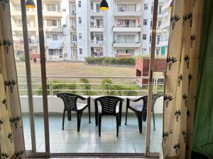 The Green Door في Lāndrān: شرفة مع كراسي وطاولة مطلة على مبنى