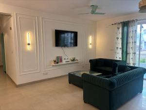 The Green Door في Lāndrān: غرفة معيشة مع أريكة وتلفزيون