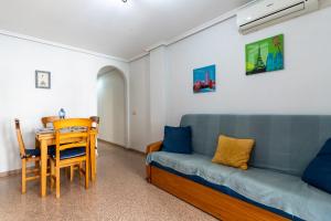 a living room with a blue couch and a table at rentafive - Nuevo - Centro - A/C in Santa Pola