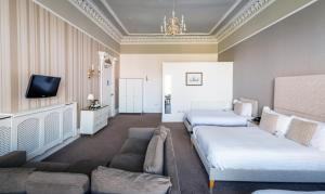 ein Hotelzimmer mit 2 Betten und einem Sofa in der Unterkunft The Belhaven Hotel in Glasgow