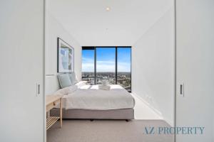 Un dormitorio blanco con una cama y una ventana grande. en Brand new Luxurious 1 Bedroom Perth CBD, en Perth