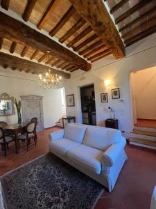 a living room with a white couch and a table at La terrazzina nel borgo apt dimora storica toscana pool&garden in Lano
