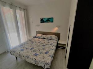 una piccola camera da letto con un letto e una finestra di Villa Bungalow 2 a Rosolina Mare