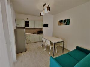 un soggiorno con un tavolo e un divano blu di Villa Bungalow 2 a Rosolina Mare