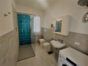 un bagno con lavandino, WC e doccia di Villa Bungalow 2 a Rosolina Mare