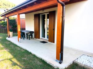 un portico coperto con tavolo e patio di Villa Bungalow 2 a Rosolina Mare