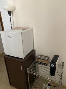 una nevera blanca en la parte superior de un armario en Armony B&B, en Bitritto