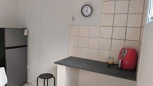 een keuken met een aanrecht met een klok aan de muur bij Dormitorio e WC privativo semanal in Valinhos