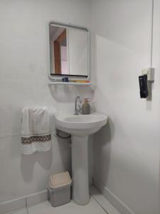 een witte badkamer met een wastafel en een spiegel bij Dormitorio e WC privativo semanal in Valinhos
