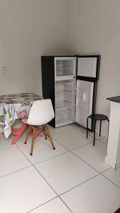 een kamer met een bed, een stoel en een koelkast bij Dormitorio e WC privativo semanal in Valinhos