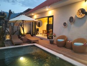 a villa with a swimming pool and a house at Villa Puri Mesari Amed in Amed