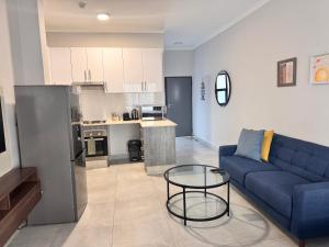 a living room with a blue couch and a table at Cozy-corner in Gaborone