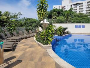 a resort swimming pool with lounge chairs next to a building at Park Veredas Flat 310 Premium in Rio Quente