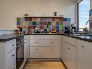 a kitchen with white cabinets and a counter top at Haus Svenja in Westerland (Sylt)